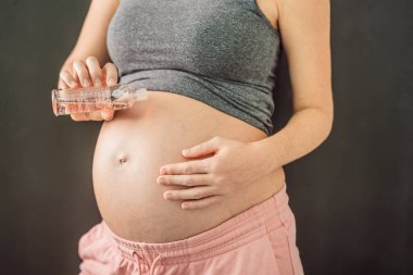 Türkiye, Antalya 02.02.2022: Hamile kadınlar için besleyici bir seçenek olan Bio Oil kadının elinde. Hamilelik boyunca bakım ve sağlığın rahatlatıcı bir görüntüsü..