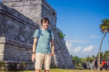 Erkek turist, Kolombiya öncesi Maya şehri Tulum, Quintana Roo, Meksika, Kuzey Amerika, Tulum, Meksika 'nın manzarasını seyrediyor. El Castillo - Şato Maya şehri Tulum ana tapınağı.