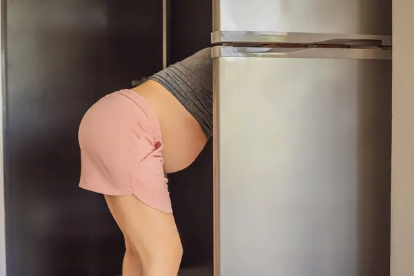 冷蔵庫の中の食べ物を探して若い妊婦 — ストック写真