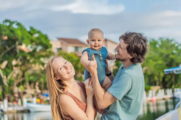 Işıl ışıl bir aile açık havada güneşli bir günün tadını çıkarır. Anne, baba ve onların tapılası bebekleri doğanın ortasında sıcaklığın tadını çıkarırlar..