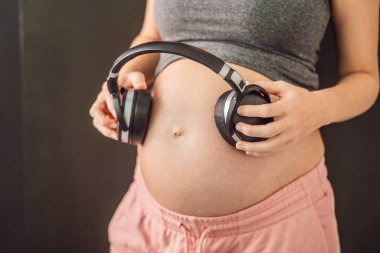 Rahimdeki melodiler: hamile bir karnına yerleştirilmiş kulaklıklar, müzikle bağlanma, anne ve bebek arasında yürek ısıtan bir bağ.
