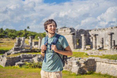 Erkek turist, Kolombiya öncesi Maya şehri Tulum, Quintana Roo, Meksika, Kuzey Amerika, Tulum, Meksika 'nın manzarasını seyrediyor. El Castillo - Şato Maya şehri Tulum ana tapınağı.