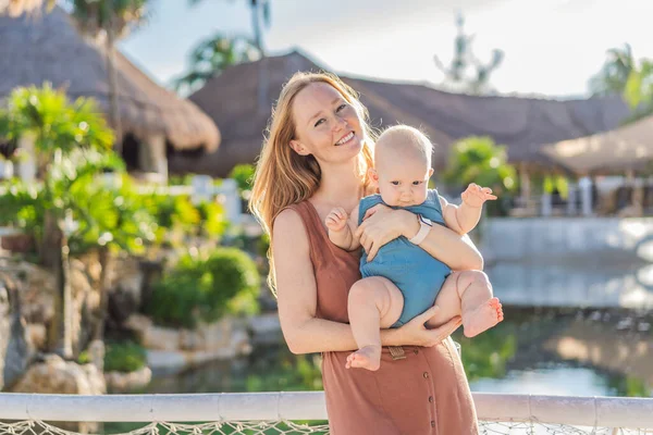 Amidst Tropical Palms Thatched Roofs Loving Mom Embraces Her Baby — Stock Photo, Image