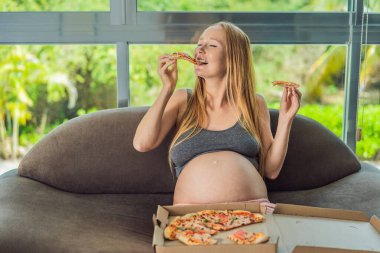 Hamile bir kadın bir dilim pizzanın tadını çıkarırken aynı zamanda zevkli ve rahatlatıcı bir zevke hasret. Heyecanlı Hamile Genç Bayan Pizza Tutma Isırmanın tadını çıkarıyor