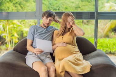 Hamilelik ve Aile Bütçesi Konsepti. Genç çift bebek bekliyor, bütçe planlıyorlar ve evde para sayıyorlar..