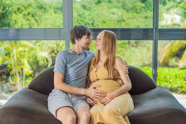 Tender Moment Captured Husband Pregnant Wife Sit Sofa Sharing Affectionate — Stock Photo, Image