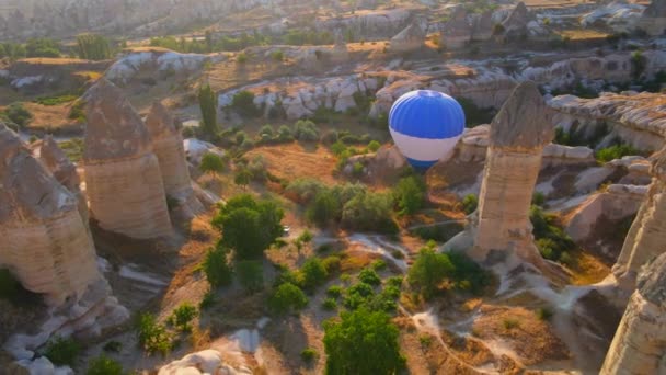 空中视频 这段视频是在卡巴多西亚天空的帆布上拍摄的 展示了热气球节迷人的景象 一只蓝色的气球优雅地滑行在轮廓分明的中间 — 图库视频影像