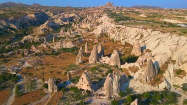 Goreme, Cappadocia, Türkiye 'nin bu büyüleyici hava fotoğrafı ile görsel deneyiminizi artırın. Aşağıdaki antik şehir, zarif oyulmuş evlerle olağanüstü cazibesini gözler önüne seriyor.