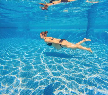 Hamile sükuneti suya daldırılmış bir kadın zarif bir şekilde havuza dalıp hamileliğin güzelliğini deniz zarafetiyle kutluyor..