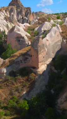 Dikey video. Türkiye 'nin Goreme kenti yakınlarındaki Cappadocias mağara evlerinin özünü yakalayan bu büyüleyici havacılık videosuyla görsel bir yolculuğa çıkın. Kuşbakışı perspektif açılır