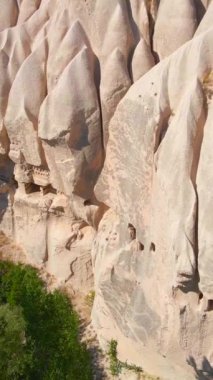 Dikey video. Türkiye 'nin Goreme kenti yakınlarındaki Cappadocias mağara evlerinin özünü yakalayan bu büyüleyici havacılık videosuyla görsel bir yolculuğa çıkın. Kuşbakışı perspektif açılır