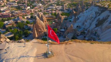 Goreme, Cappadocia, Türkiye 'nin bu büyüleyici klibiyle görsel deneyimlerinizi artırın. Goreme tepesinin tepesinde Türk cumhuriyetine ait el sallayan bir bayrak bulunmaktadır. Şey...
