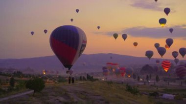 Goreme, Türkiye - 2.08.2022. Kapadokyaca gökyüzünün tuvaline yansıyan bu video, sıcak hava balonu festivalinin büyüleyici gösterisini sergiliyor. Canlı balonlar zarif bir şekilde yükseliyor.