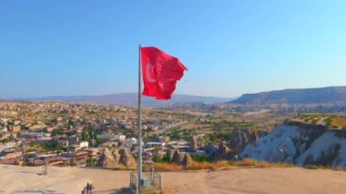 Goreme, Cappadocia, Türkiye 'nin bu büyüleyici klibiyle görsel deneyimlerinizi artırın. Goreme tepesinin tepesinde Türk cumhuriyetine ait el sallayan bir bayrak bulunmaktadır. Şey...
