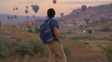 Erkek turist, Türkiye 'nin Kapadokya kentinde sıcak hava balonları festivalinin tadını çıkarıyor. Türkiye 'ye İyi Yolculuklar konsepti.