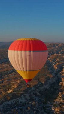 Dikey video. Bu klipte, Türkiye 'nin Kapadokya kentindeki gökyüzü sıcak hava balonlarından oluşan bir kaleydoskopla canlanıyor. Bölgelerin, ikonik vadilerin, kayaların ve tarlaların arka planına karşı
