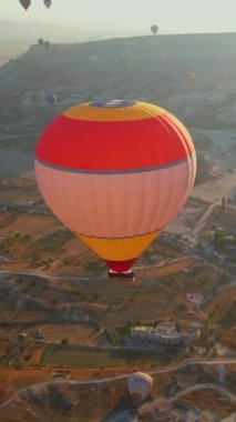 Dikey video. Bu klipte, Türkiye 'nin Kapadokya kentindeki gökyüzü sıcak hava balonlarından oluşan bir kaleydoskopla canlanıyor. Bölgelerin, ikonik vadilerin, kayaların ve tarlaların arka planına karşı