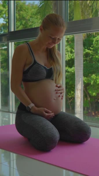 Вертикальное Видео Молодая Беременная Женщина Выполняет Упражнения Йоги Своей Квартире — стоковое видео