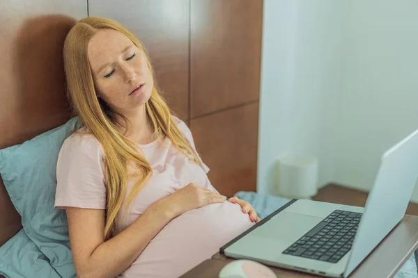 Weary pregnant woman, tired of working from home, navigates the challenges of balancing professional tasks with pregnancy demands.