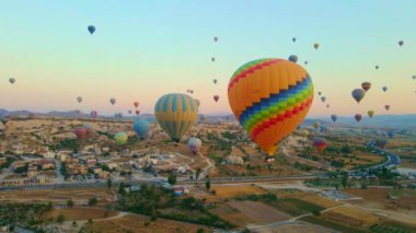Hava videosu. Kapadokyaca gökyüzünün tuvaline yansıyan bu video, sıcak hava balonu festivalinin büyüleyici görüntüsünü sergiliyor. Canlı balonlar zarif bir şekilde vadilerde yükseliyor.