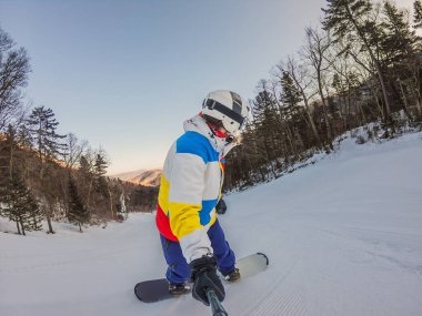 Cesur bir adam, kar yamaçlarını ustalıkla fetheder. Snowboard 'da manevra yaparken yeteneğini ve heyecanını gösterir. Kış macerasının özünü yakalar..