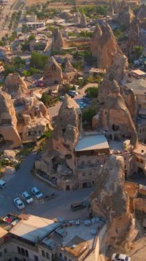Dikey video. Goreme 'in hava görüntüleri, Kapadokya, Türkiye. Aşağıdaki antik şehir, kayalara güzelce oyulmuş evlerle olağanüstü çekiciliğini gözler önüne seriyor. Eşsiz kaya oluşumları