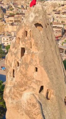 Dikey video. Goreme 'in hava görüntüleri, Kapadokya, Türkiye. Aşağıdaki antik şehir, kayalara güzelce oyulmuş evlerle olağanüstü çekiciliğini gözler önüne seriyor. Eşsiz kaya oluşumları