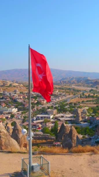 垂直录像 土耳其Cappadocia Goreme的空中库存录像 图尔基共和国的一面飘扬的国旗矗立在戈雷梅山顶之上 — 图库视频影像