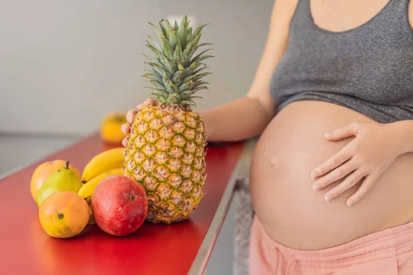 Embracing a healthy choice, a pregnant woman prepares to enjoy a nutritious moment, gearing up to eat fresh fruit and nourish herself during her pregnancy.