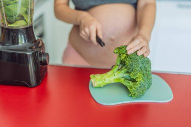 Besleyici bir seçimi kucaklayan hamile bir kadın neşeli bir şekilde canlı bir sebze kokteyli hazırlar ve hamilelik yolculuğunda en iyi koşullarda yaşayabilmesi için sağlıklı malzemelere öncelik verir..