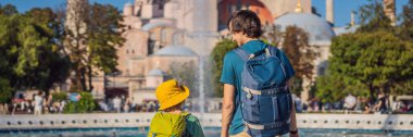 BANNER, Uzun Ömürlü Baba ve Oğul Turistler, Türkiye 'nin İstanbul kentindeki ünlü İslami Tarihi Cami Ayasofya Katedrali' nin güzel manzarasının keyfini çıkarıyorlar. Çocuk konseptiyle seyahat etmek. Güneşli bir gün