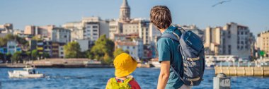 Baba ve oğul turistler Türkiye 'de İstanbul' un siluetinin keyfini çıkarırken, Beyoğlu 'nda Galata kulesinin tepesinde ise Altın Boynuz manzaralı eski evler bulunuyor. BANNER, BÜYÜK
