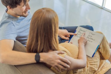 Bekleyen çift, doğmamış oğulları için sevinçle bir isim seçiyor. Büyüyen aileleri için anlamlı bir kimlik seçmenin özel anının tadını çıkarıyorlar..