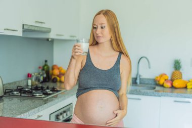 Weighing the pros and cons of milk during pregnancy, a thoughtful pregnant woman stands in the kitchen with a glass, contemplating the decision to include or avoid milk for her and her babys well clipart