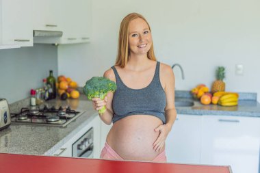Besin açısından zengin bir seçimi kucaklayan hamile bir kadın, hamileliği boyunca sağlıklı ve besleyici seçenekler sunarak sağlıklı bir brokoli servisinin keyfini çıkarmaya hevesle hazırlanıyor..