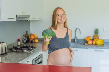 Besin açısından zengin bir seçimi kucaklayan hamile bir kadın, hamileliği boyunca sağlıklı ve besleyici seçenekler sunarak sağlıklı bir brokoli servisinin keyfini çıkarmaya hevesle hazırlanıyor..