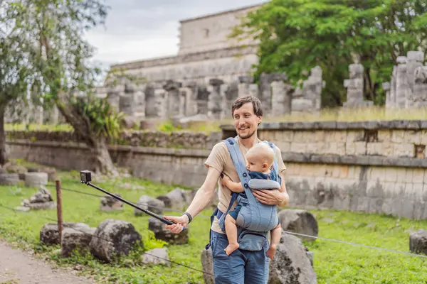 Father and son tourists observing the old pyramid and temple of the castle of the Mayan architecture known as Chichen Itza. These are the ruins of this ancient pre-columbian civilization and part of