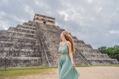 Beautiful tourist woman observing the old pyramid and temple of the castle of the Mayan architecture known as Chichen Itza. These are the ruins of this ancient pre-columbian civilization and part of clipart