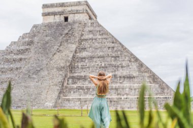 Chichen Itza olarak bilinen Maya mimarisinin eski piramidini ve tapınağını gözlemleyen güzel bir turist kadın. Bunlar eski Kolombiya öncesi medeniyetin kalıntıları.