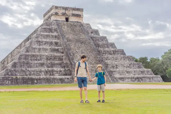 Baba ve oğul turistler Chichen Itza olarak bilinen Maya mimarisinin eski piramit ve tapınağını izliyorlar. Bunlar eski Kolombiya öncesi medeniyetin kalıntıları.