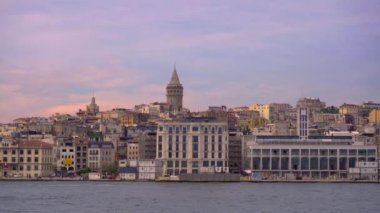 Tekneyle sakin bir yavaş çekim yolculuğu İstanbullar 'ın ikonik Galata Kulesi' nin çarpıcı bir görüntüsünü sunuyor. Şehrin ufuk çizgisinin üzerinde görkemli bir şekilde yükseliyor.