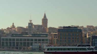 Tekneyle sakin bir yavaş çekim yolculuğu İstanbullar 'ın ikonik Galata Kulesi' nin çarpıcı bir görüntüsünü sunuyor. Şehrin ufuk çizgisinin üzerinde görkemli bir şekilde yükseliyor.