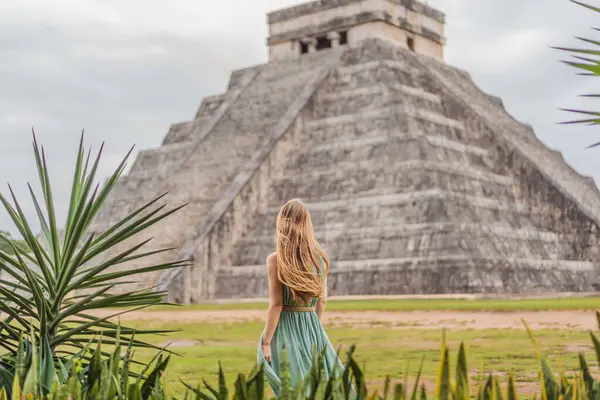 stock image Beautiful tourist woman observing the old pyramid and temple of the castle of the Mayan architecture known as Chichen Itza. These are the ruins of this ancient pre-columbian civilization and part of