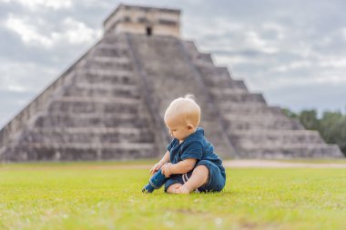 Baby traveler, tourists observing the old pyramid and temple of the castle of the Mayan architecture known as Chichen Itza. These are the ruins of this ancient pre-columbian civilization and part of clipart
