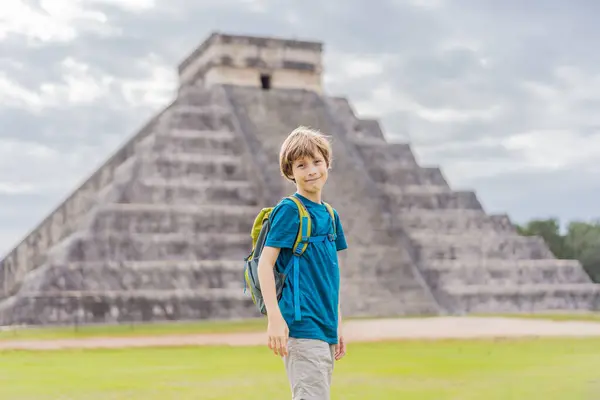 stock image Boy traveler, tourists observing the old pyramid and temple of the castle of the Mayan architecture known as Chichen Itza. These are the ruins of this ancient pre-columbian civilization and part of