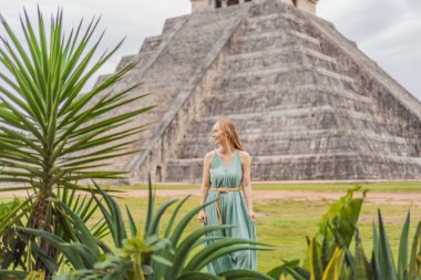 Chichen Itza olarak bilinen Maya mimarisinin eski piramidini ve tapınağını gözlemleyen güzel bir turist kadın. Bunlar eski Kolombiya öncesi medeniyetin kalıntıları.
