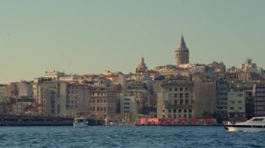 5.08.2022, ISTANBUL, TURKEY: Tekneyle sakin bir yolculuk Istanbuls ikonik Galata Kulesi 'nin çarpıcı bir görüntüsünü sunuyor,