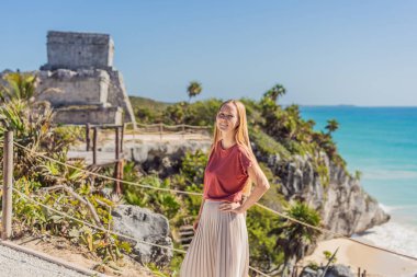 Kolombiya öncesi Maya şehri Tulum, Quintana Roo, Meksika, Kuzey Amerika, Tulum, Meksika manzarasının tadını çıkaran bir kadın turist. El Castillo - Şato Maya şehri Tulum ana tapınağı.