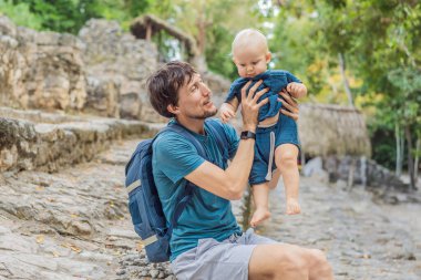 Baba ve oğul turistler Coba, Meksika 'da. Meksika 'daki antik Maya şehri. Coba arkeolojik bir alan ve Yucatan Yarımadası 'nın ünlü bir simgesidir. Meksika 'da bir piramidin üzerindeki bulutlu gökyüzü.