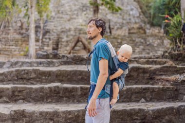 Baba ve oğul turistler Coba, Meksika 'da. Meksika 'daki antik Maya şehri. Coba arkeolojik bir alan ve Yucatan Yarımadası 'nın ünlü bir simgesidir. Meksika 'da bir piramidin üzerindeki bulutlu gökyüzü.